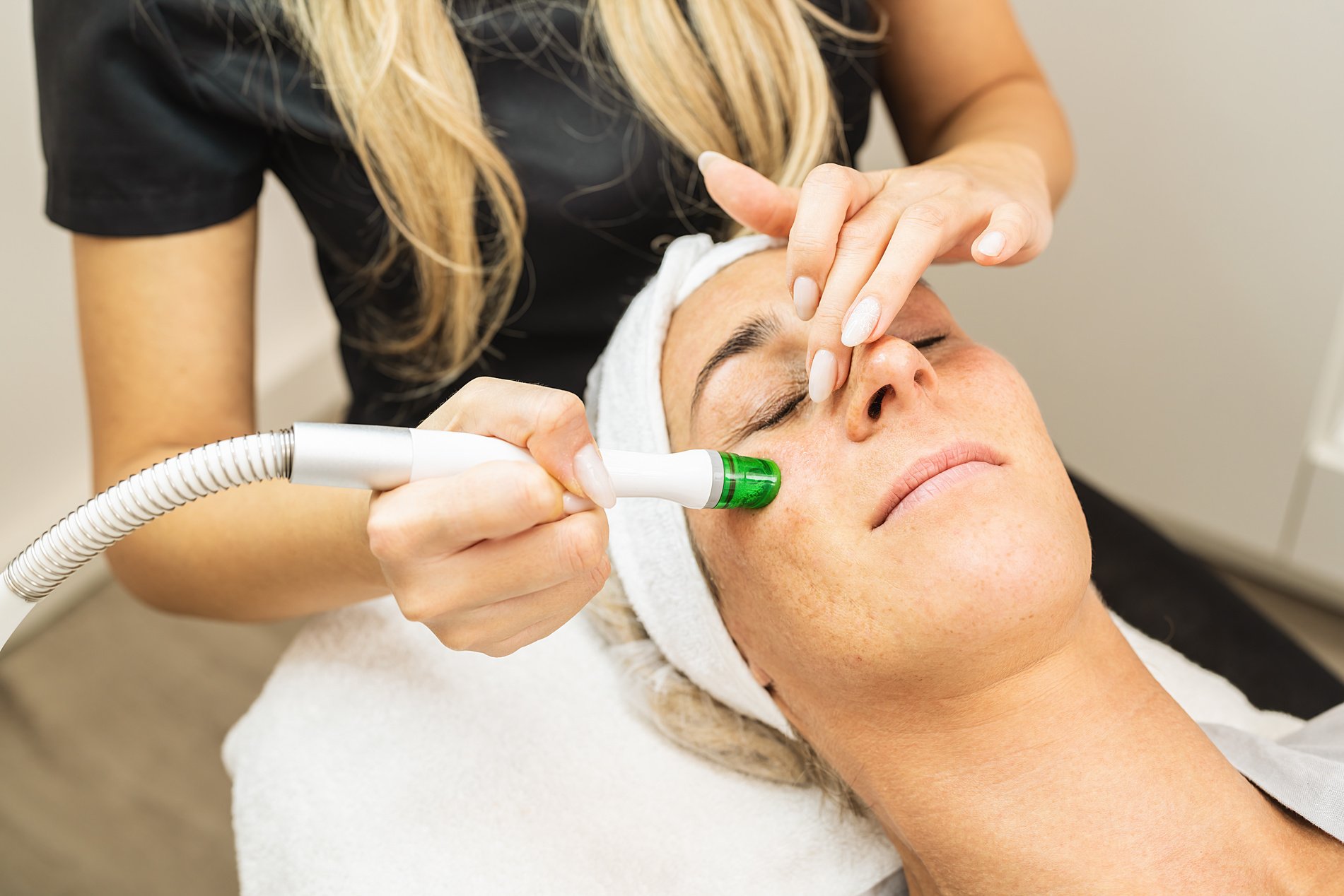 Face of a beautiful pleasant woman being cleansed during aquafac